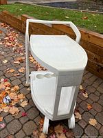 Overall view of white resin patio cart showing top shelf and handle