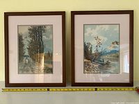 Front view of two framed W. T. Wood watercolours with tape measure for size