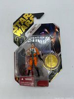 Front view of sealed Biggs Darklighter figure on card with coin