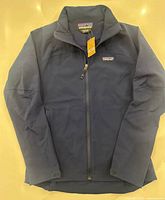 Full view of navy Patagonia Adze jacket laid flat