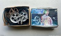 Open box showing two metal pulleys, blue vinyl-coated clothesline cord and retail box lid
