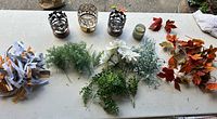 All items on table showing candle holders, votive, faux florals, ribbon