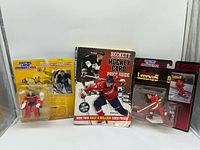 Group shot of two sealed action figure packages and price guide book