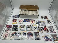 Long storage box filled with trading cards and sample cards spread out