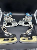 Two pairs of Bauer youth hockey skates displayed side by side