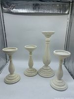 All four white wood candle holders grouped