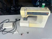 Kenmore sewing machine with foot pedal and accessories laid out