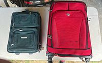 Green and red rolling suitcases side by side on table