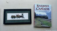 Book and framed cross-stitch laid side by side on floor