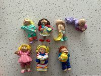 Seven assorted 1984 Cabbage Patch Kids PVC figurines on countertop