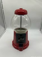 Front view of red gumball machine showing full shape and glass globe