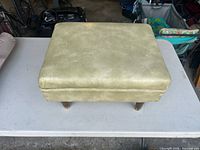 Top and side view of square green vinyl ottoman on table