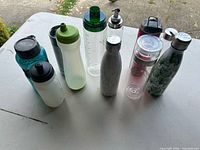 Group shot of all ten reusable water bottles showing colours, materials and lid styles