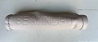 Rolled beige yoga mat showing full length with embossed wording