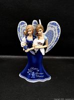 Front view of twin-angel figurine showing inscription and Blue Willow detailing