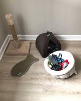 Overall lot showing scratching post, fish-shaped scratcher, cat cave, round bed with toys inside