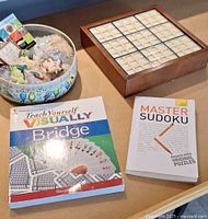 Overview showing tin of magnets, books, and part of Sudoku board