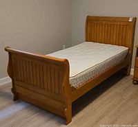 Complete twin sleigh bed frame with mattress in place