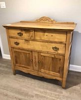 Full frontal view showing overall structure: two small drawers, one wide drawer, lower cabinet doors, missing handle, misaligned side boards