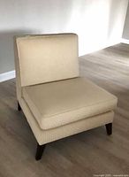 Full view of cream armless slipper chair