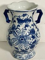 Front view of blue and white floral handled vase