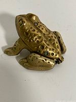 Side view of brass frog trinket box closed
