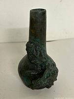 Full view of bronze vase front showing neck, body, relief detail, patina