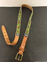 Full view of leather belt showing beadwork and buckle