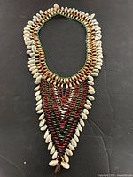 Full view of necklace showing length, beadwork and cowrie shell fringe