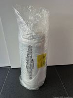 Rolled sealed mattress topper in plastic wrap