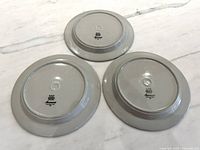 backs of three Arabia Anemone plates showing maker marks