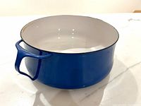 Angled side view of blue enamel casserole pot showing exterior color and one handle