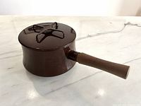 Side view of saucepan with lid on showing color, handle, and lid design