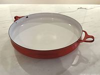 Top view of red Dansk Kobenstyle paella pan showing white interior