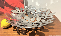 Overall view of metal floral cut-out fruit bowl on table