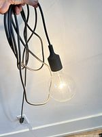 Pendant lamp lit, showing cord, plug and socket