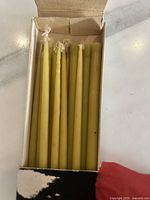 Open Dansk Designs Ltd box showing six green tiny taper candles.