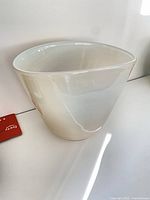 Off-white blown glass bowl displayed on shelf