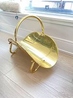 Overall view of brass log holder showing handle, tray and legs
