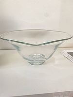Clear glass flared bowl on shelf