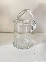 clear cylindrical glass vase with arched handle