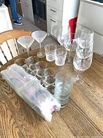 All glassware grouped on table showing wine, martini, lowball, highball glasses and sealed bundle