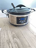 Full view of stainless steel Hamilton Beach programmable slow cooker showing digital control panel and locking lid