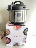 Instant Pot pressure cooker sitting on its retail box