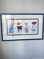 Framed floral print with four flower panels, blue frame, glass front