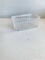 angled view of clear rectangular ribbed glass bowl on countertop