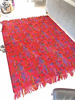 Overview of woven throw laid flat showing full pattern and fringe