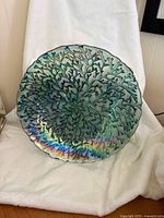 Front view of turquoise iridescent glass plate showing full coral pattern