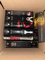 Box containing six fiction books including Stephenie Meyer Twilight Saga and two Stephen King novels