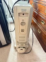 Front view of De'Longhi Safeheat oil-filled radiator heater showing control panel and casters